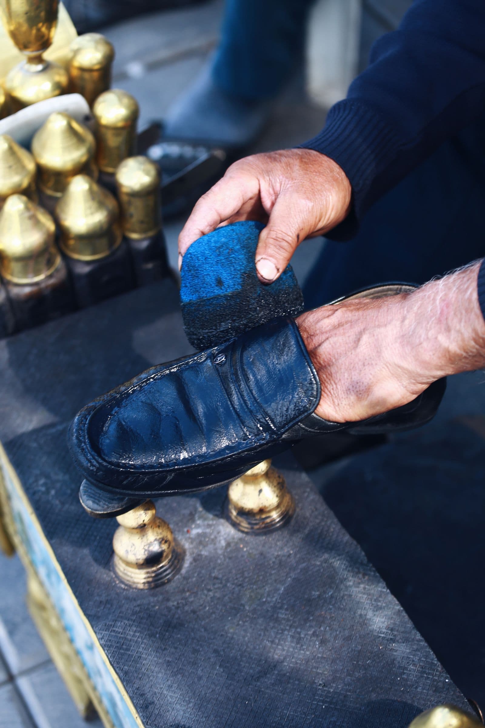 A leather shoe being carefully cleaned by hand